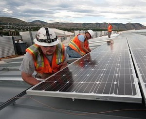 Workers install solar on a rooftop. 