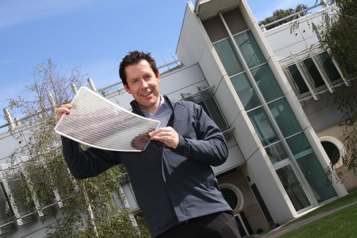 Scott Watkins holding a sheet of flexible solar cells. Courtesy CSIRO.
